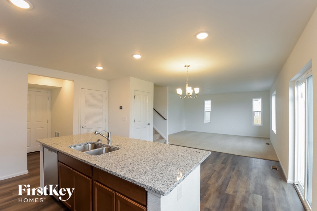 the view of the kitchen and living room from the counter top in a new home