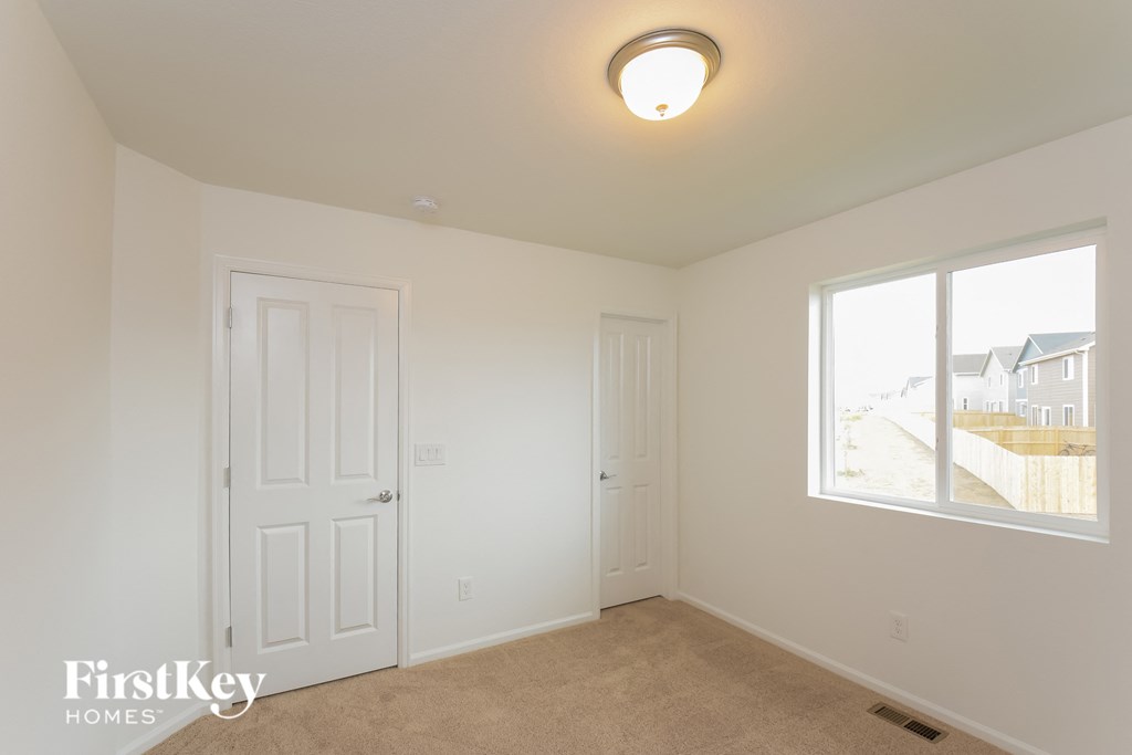 a bedroom with two closets and a window