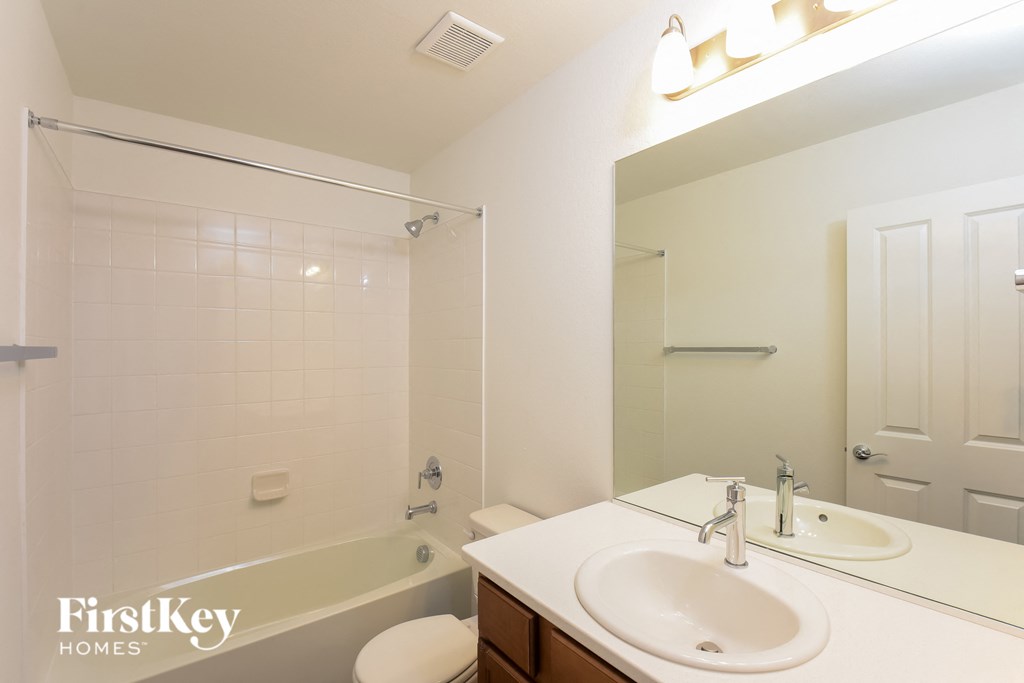 a bathroom with a tub and a sink and a mirror