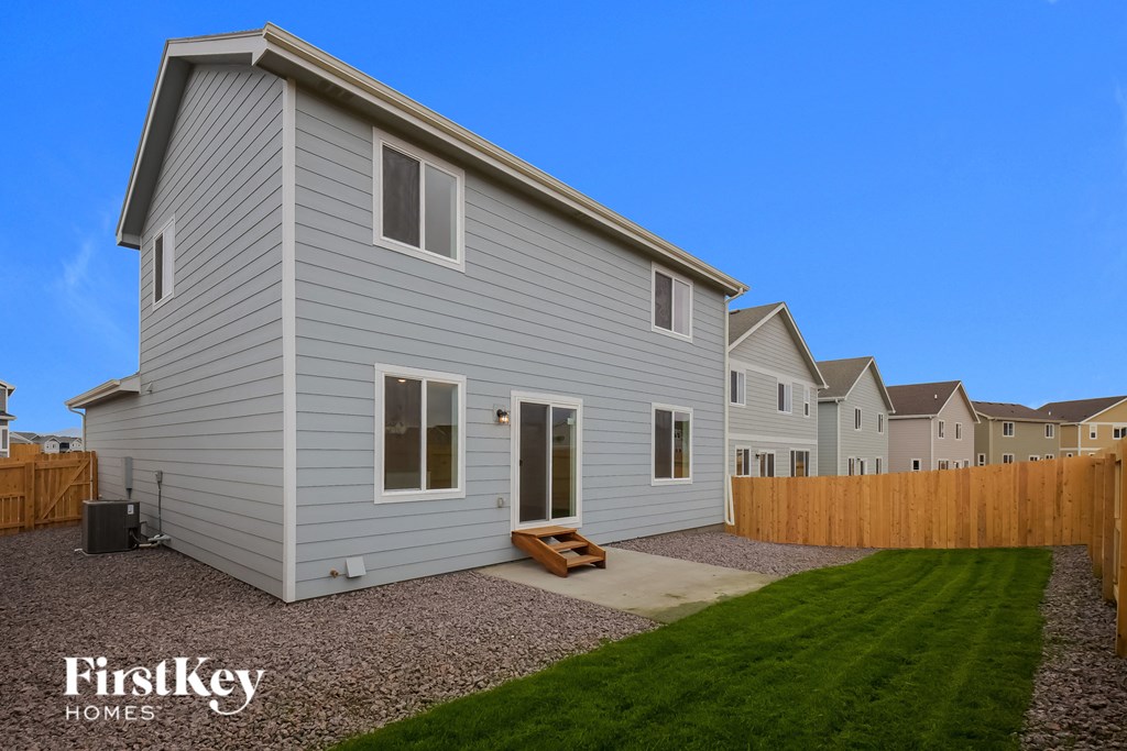 a white house with a yard and a wooden fence