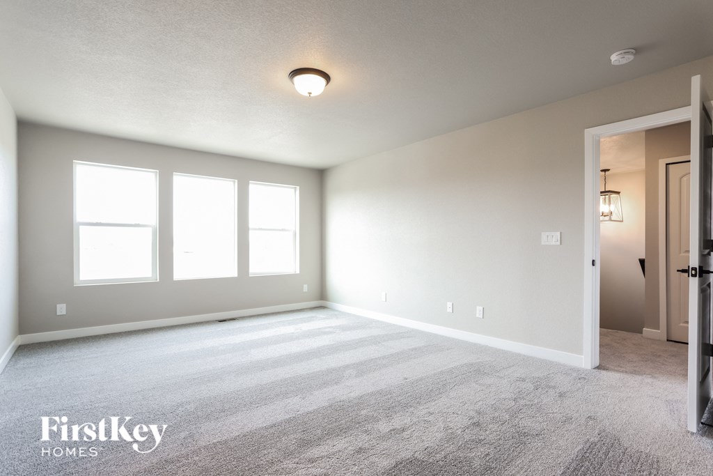 a master bedroom with carpeted flooring and white walls
