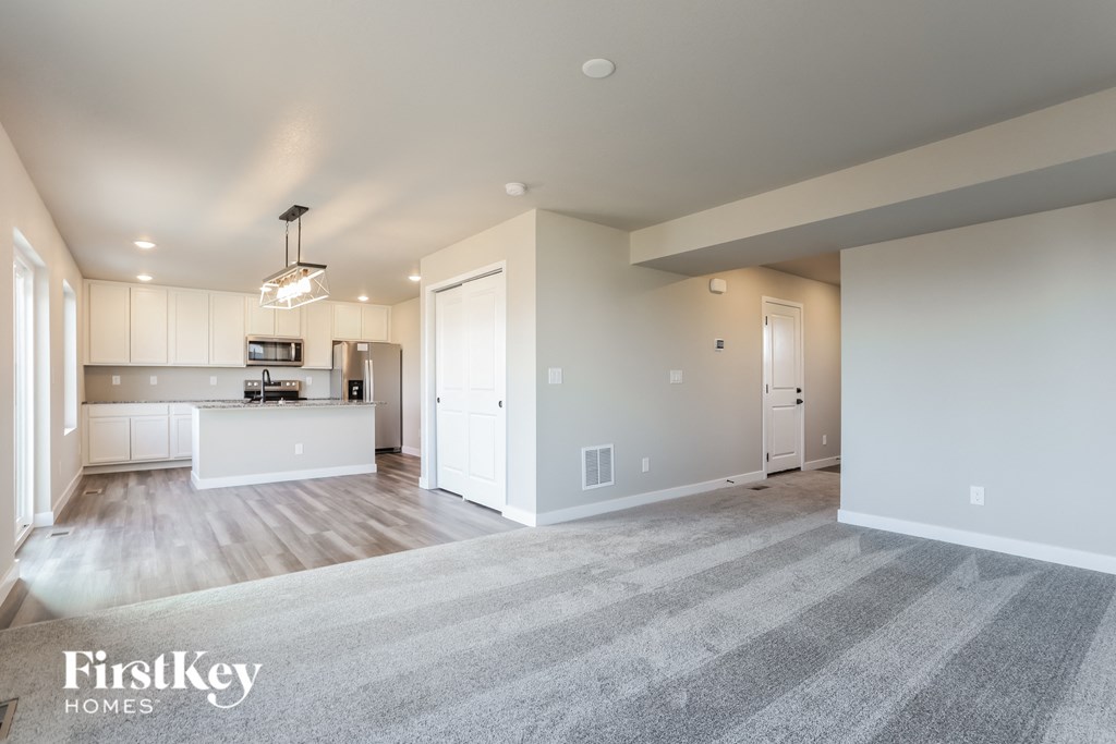 the living room and kitchen of an empty house