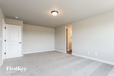 a spacious living room with white carpet and a white door