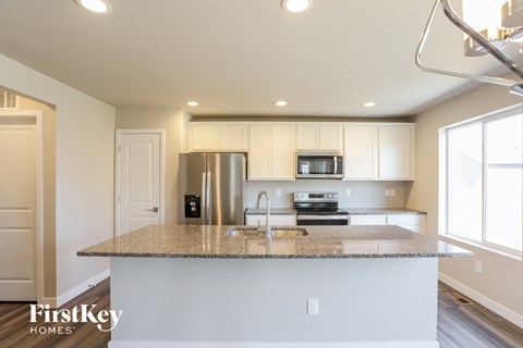 a kitchen with a granite counter top and a stainless steel refrigerator