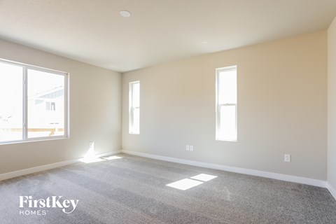a living room with a carpeted floor and two windows