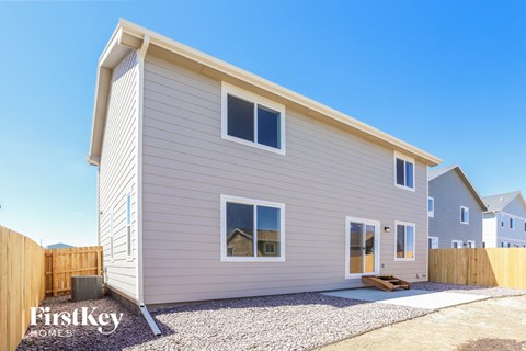 the exterior of a new home with a wooden fence
