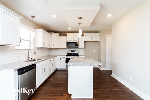 a white kitchen with marble counter tops and white cabinets