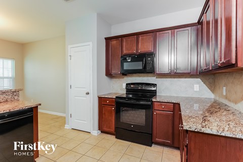 A kitchen with brown cabinets and black appliances.