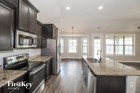 A kitchen with dark wood cabinets and granite countertops.
