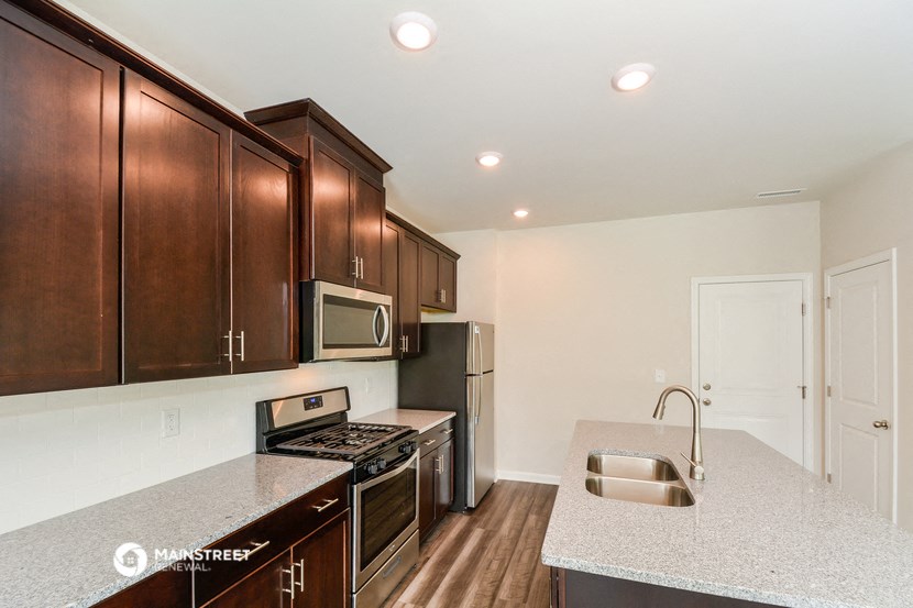 a kitchen with wooden cabinets and granite counter tops and a sink