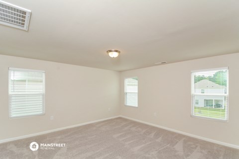 the spacious living room with carpet and windows