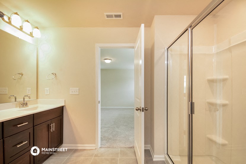 a bathroom with a shower and a sink and a mirror