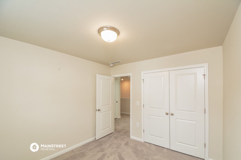 a bedroom with two closets and a door to a hallway