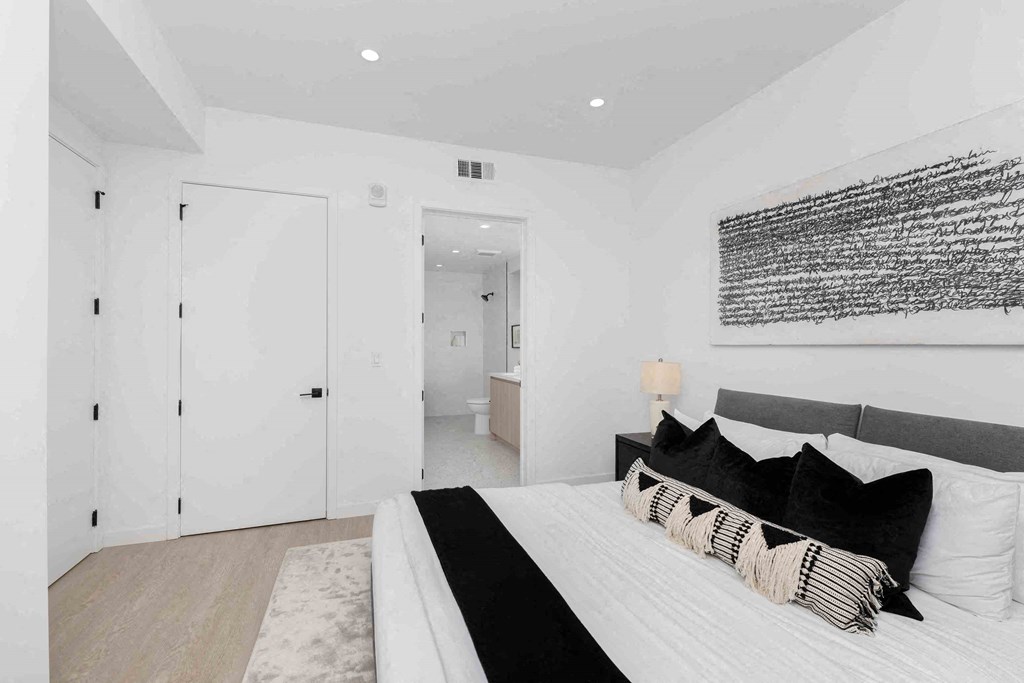 a white bedroom with a large bed and a white closet