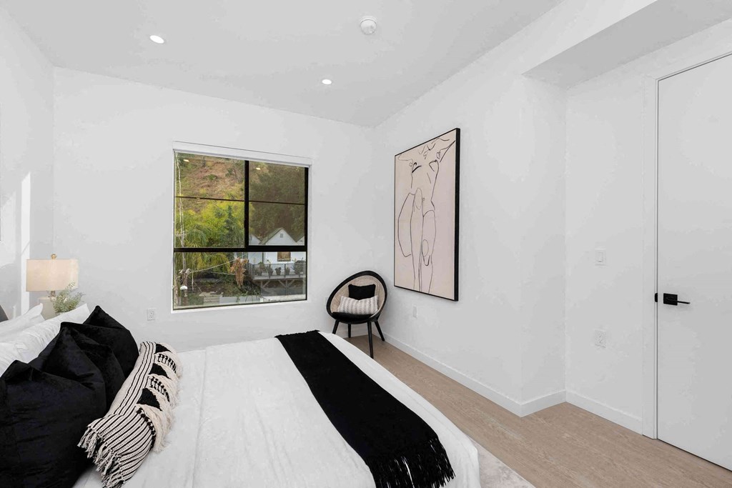 a white bedroom with a bed and a window