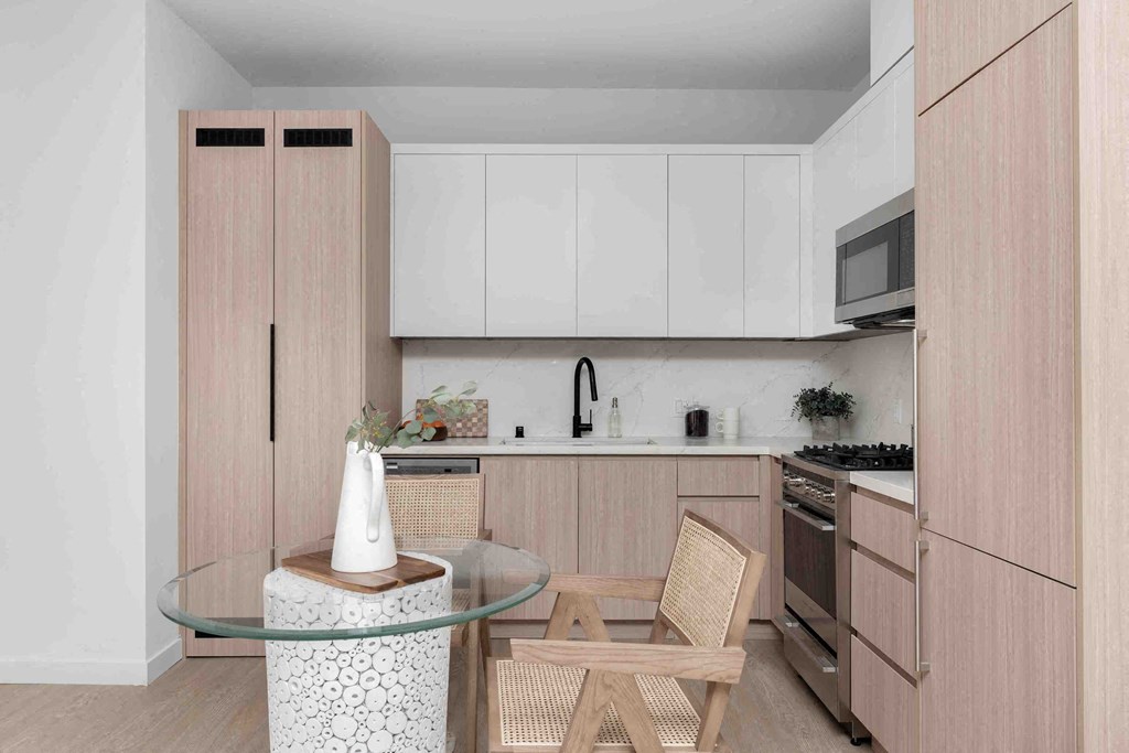 a kitchen with wooden cabinets and a table with two chairs