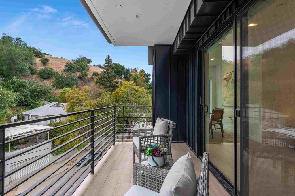 a balcony with two chairs and a table and a sliding glass door