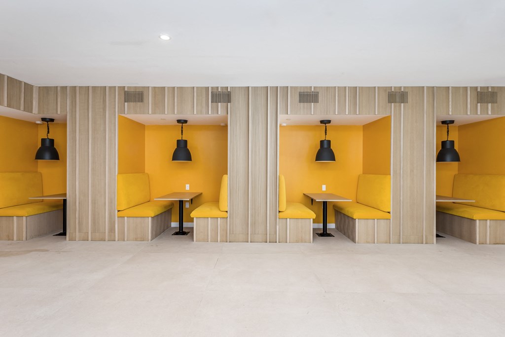 a row of yellow benches and tables in a room