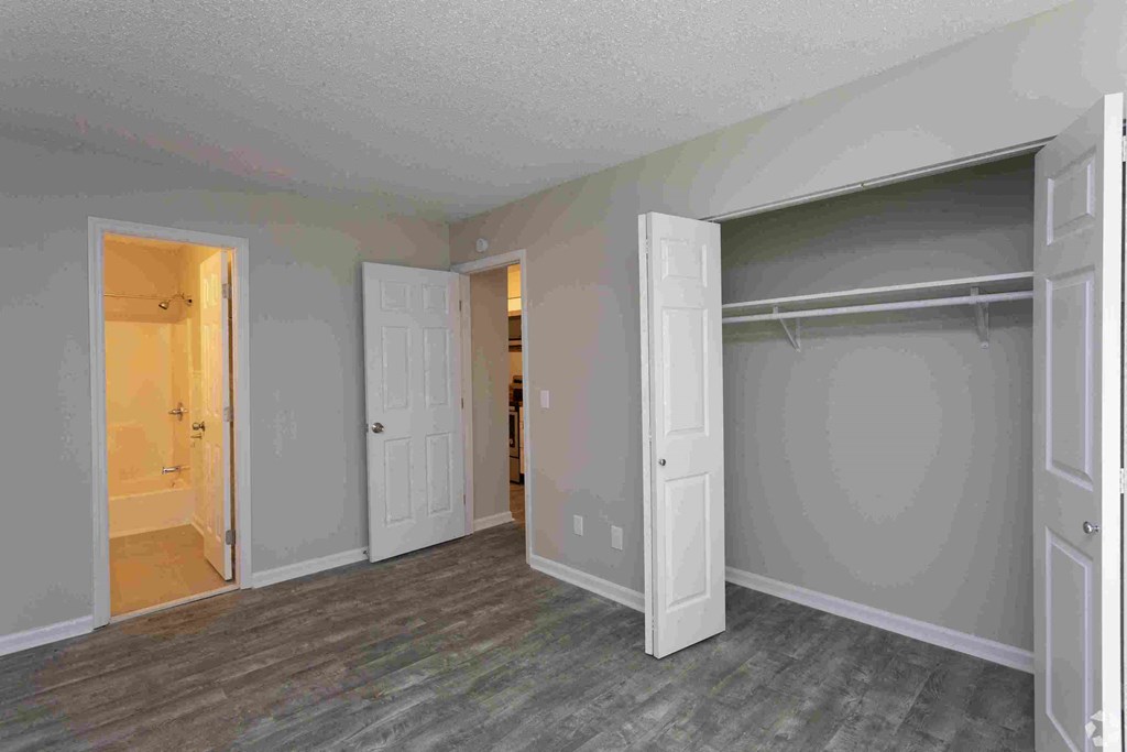 a bedroom with a closet and a door to a bathroom