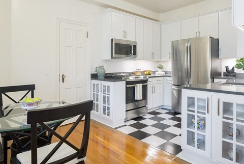a kitchen with a checkered floor and a stainless steel refrigerator