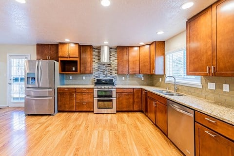 a large kitchen with wooden cabinets and stainless steel appliances