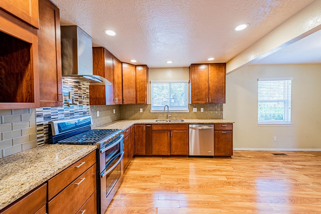 a large kitchen with wooden cabinets and granite counter tops