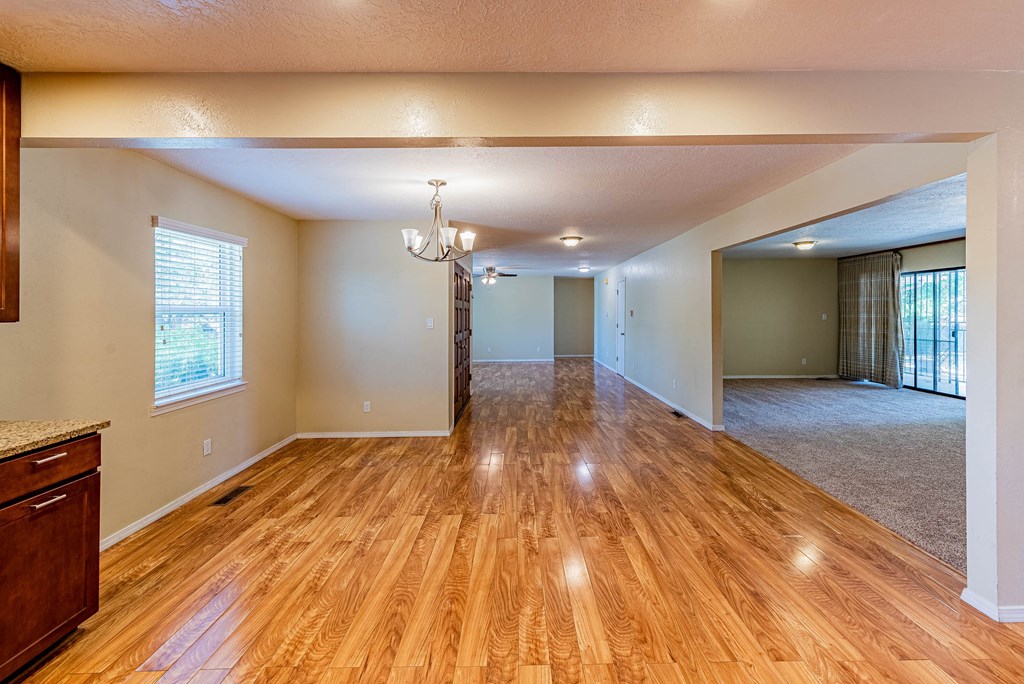 an empty living room and dining room with wood floors