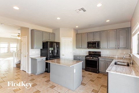 a large kitchen with stainless steel appliances and gray cabinets