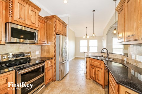A kitchen with wooden cabinets and a black countertop.