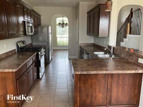 a large kitchen with wooden cabinets and a stainless steel refrigerator