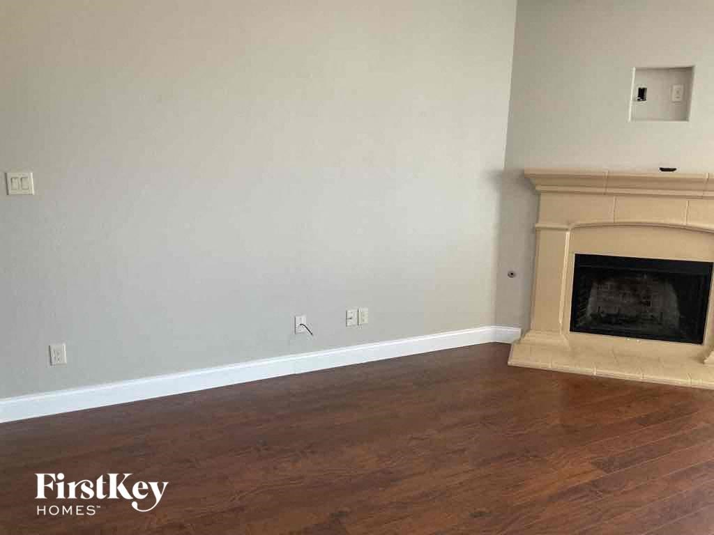 a living room with a fireplace and wooden floors