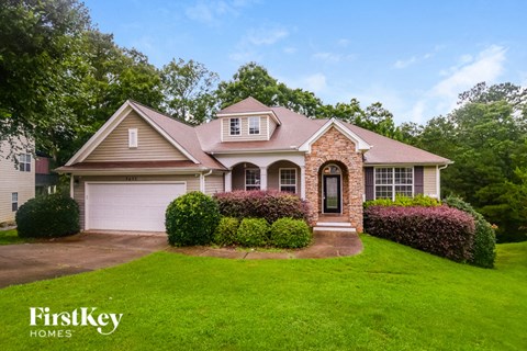 the front of a house with a lawn and a driveway