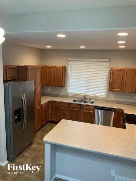 A kitchen with wooden cabinets and a stainless steel refrigerator.
