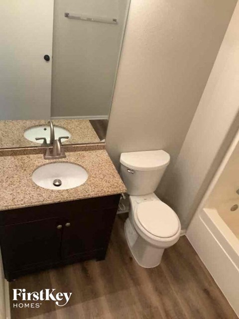 A bathroom with a toilet, sink, and a tub.