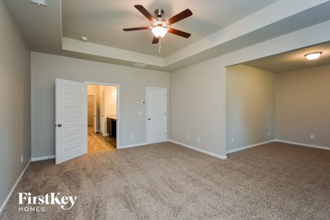 a living room with carpet and a ceiling fan
