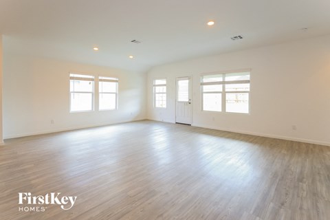 an empty living room with white walls and wood floors