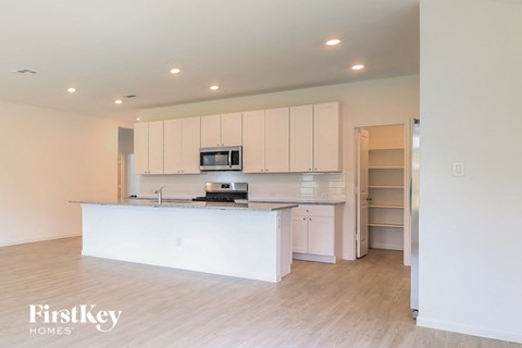 a white kitchen with a large island and white cabinets