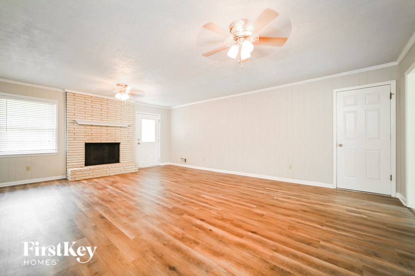 a living room with a fireplace and a ceiling fan