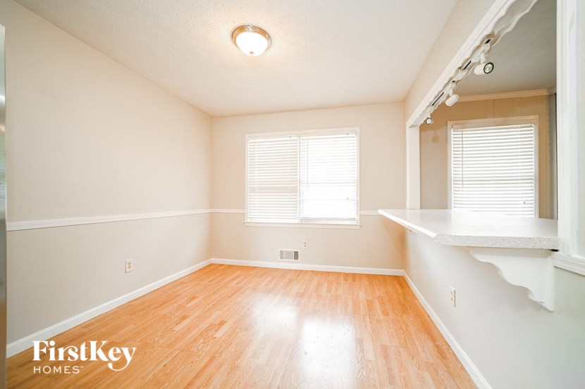 an empty living room with wood floors and a window