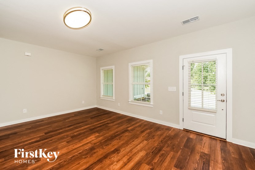 an empty living room with wood flooring and a white door