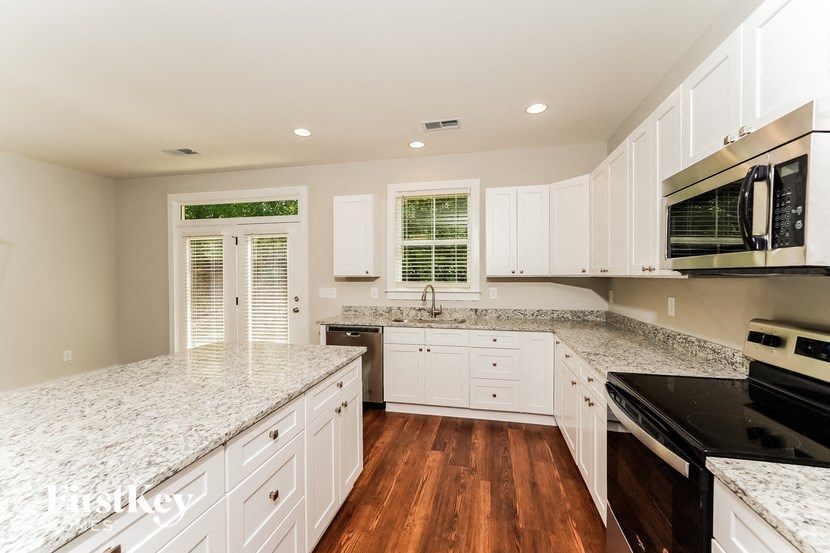 a kitchen with marble counter tops and white cabinets