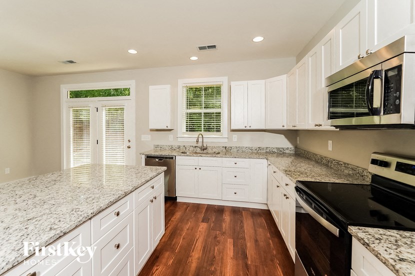 a kitchen with marble counter tops and white cabinets