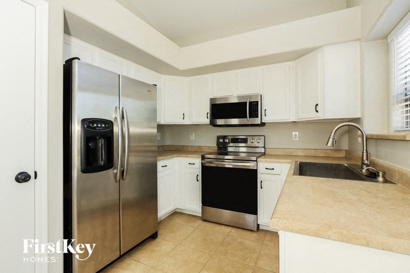 a kitchen with stainless steel appliances and white cabinets
