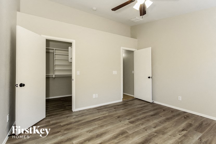 an empty room with a closet and a ceiling fan