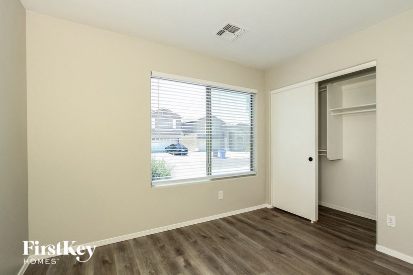 the living room of an apartment with a large window and wood flooring