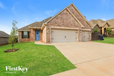 a large brick house with a blue door and a lawn