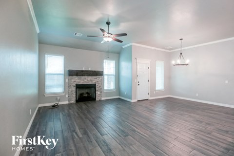 a living room with a fireplace and a ceiling fan