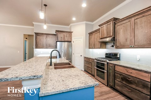 a kitchen with wooden cabinets and granite counter tops and a sink