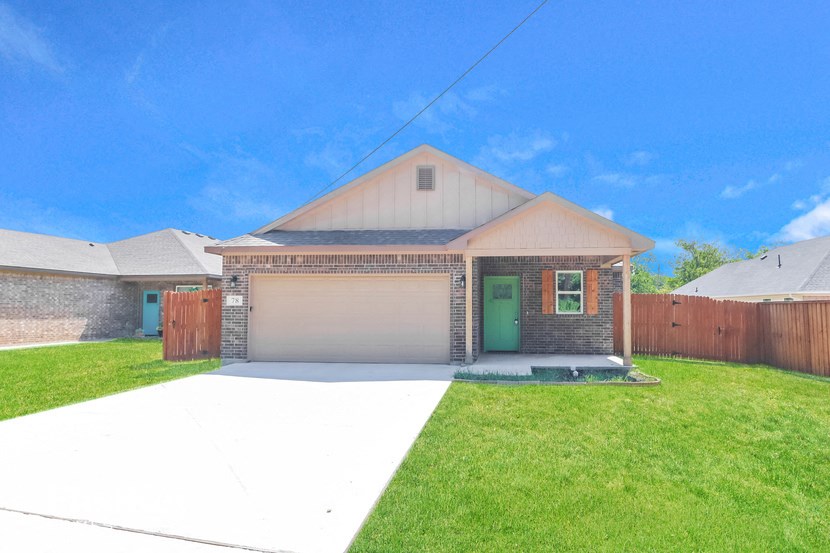a house with a driveway and a green door