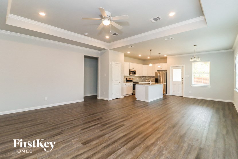 the living room and kitchen of a new home with wood flooring